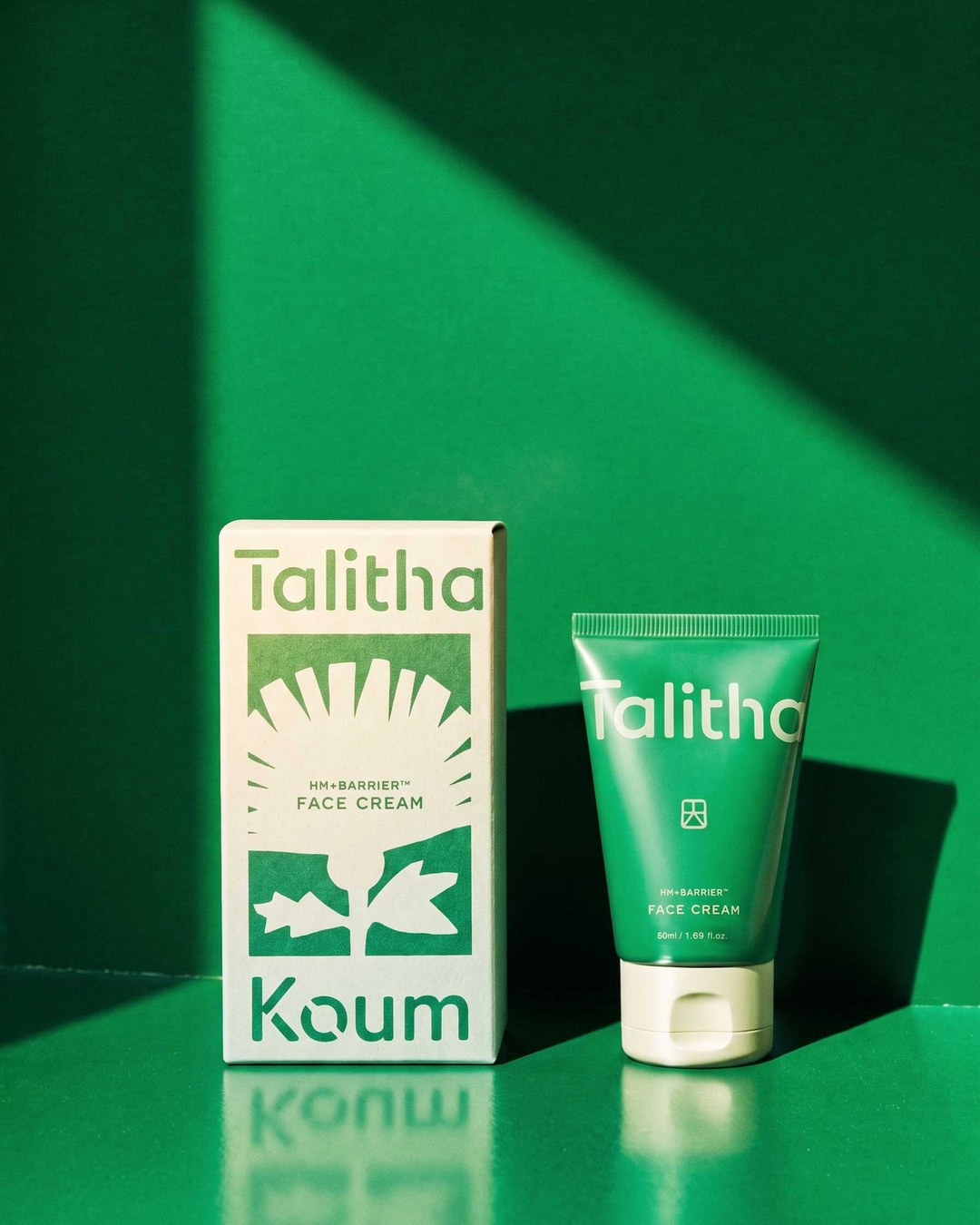 Face Cream tube and carton on an emerald backdrop in hard sunlight