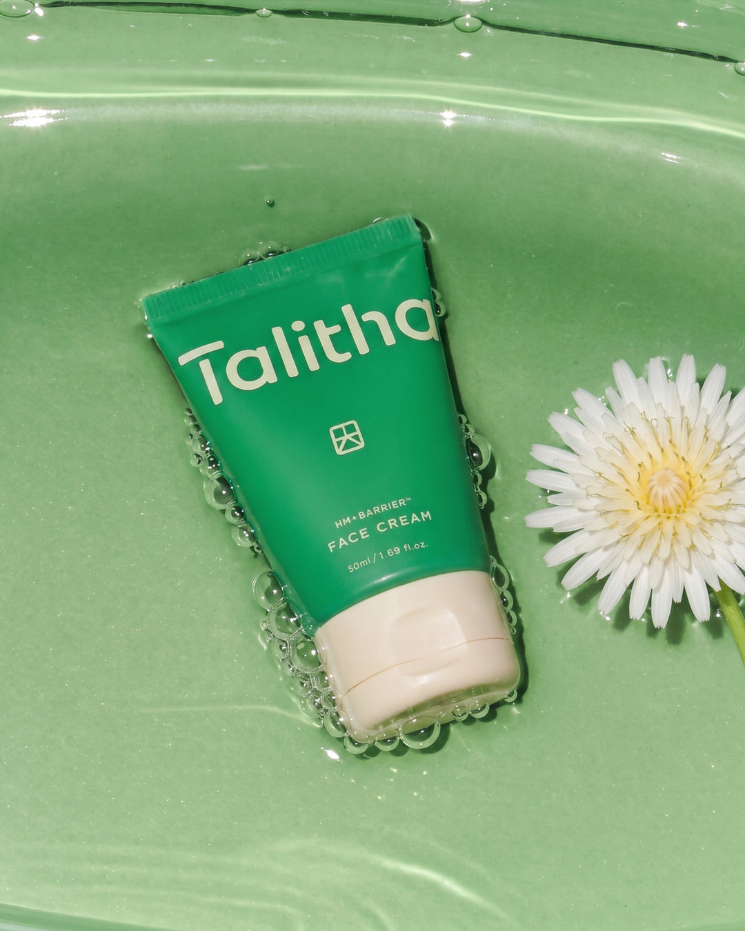 Face Cream resting in water beside a White Dandelion