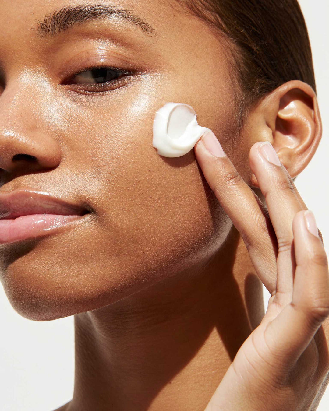 Applying Face Cream to the cheek