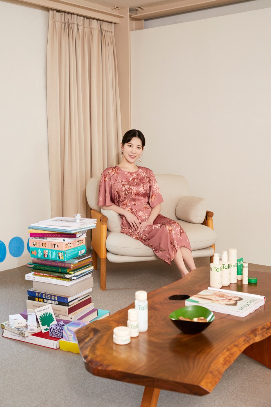 Talitha Koum founder Moonsun Chai seated beside the brand’s skincare products.
