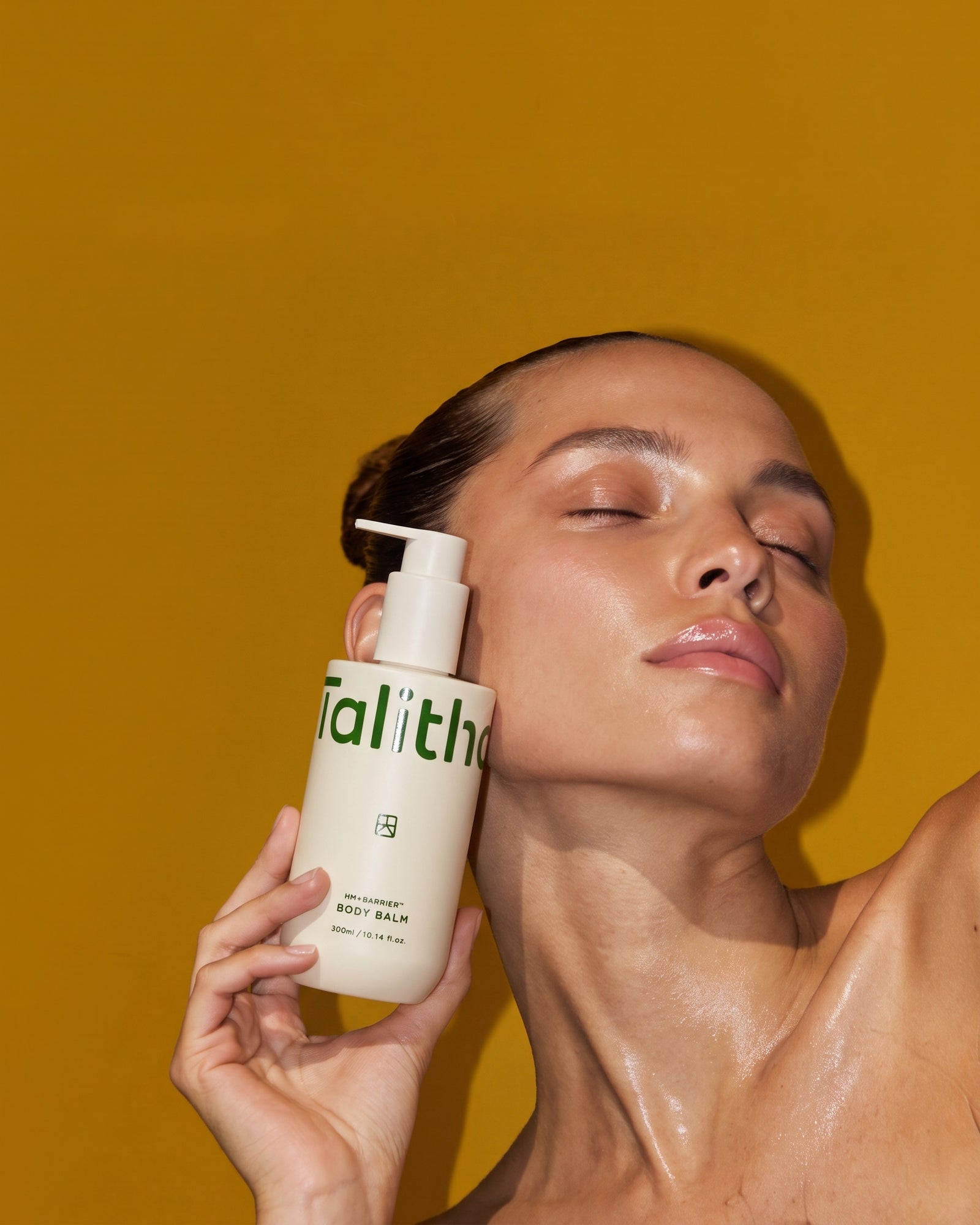A model holding HM+Barrier Body Balm against her cheek