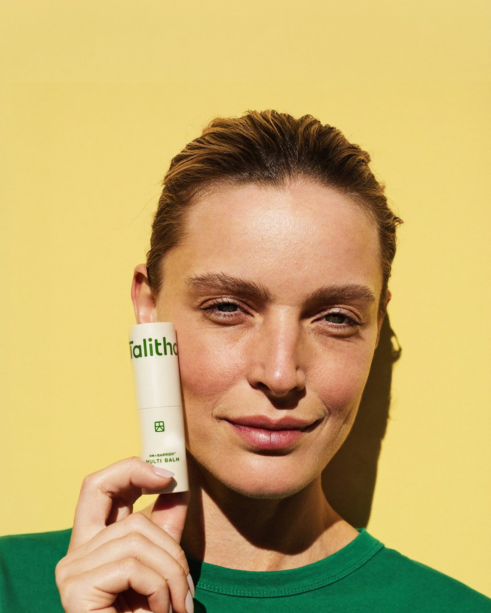 A model holding Multi Balm stick against her cheek