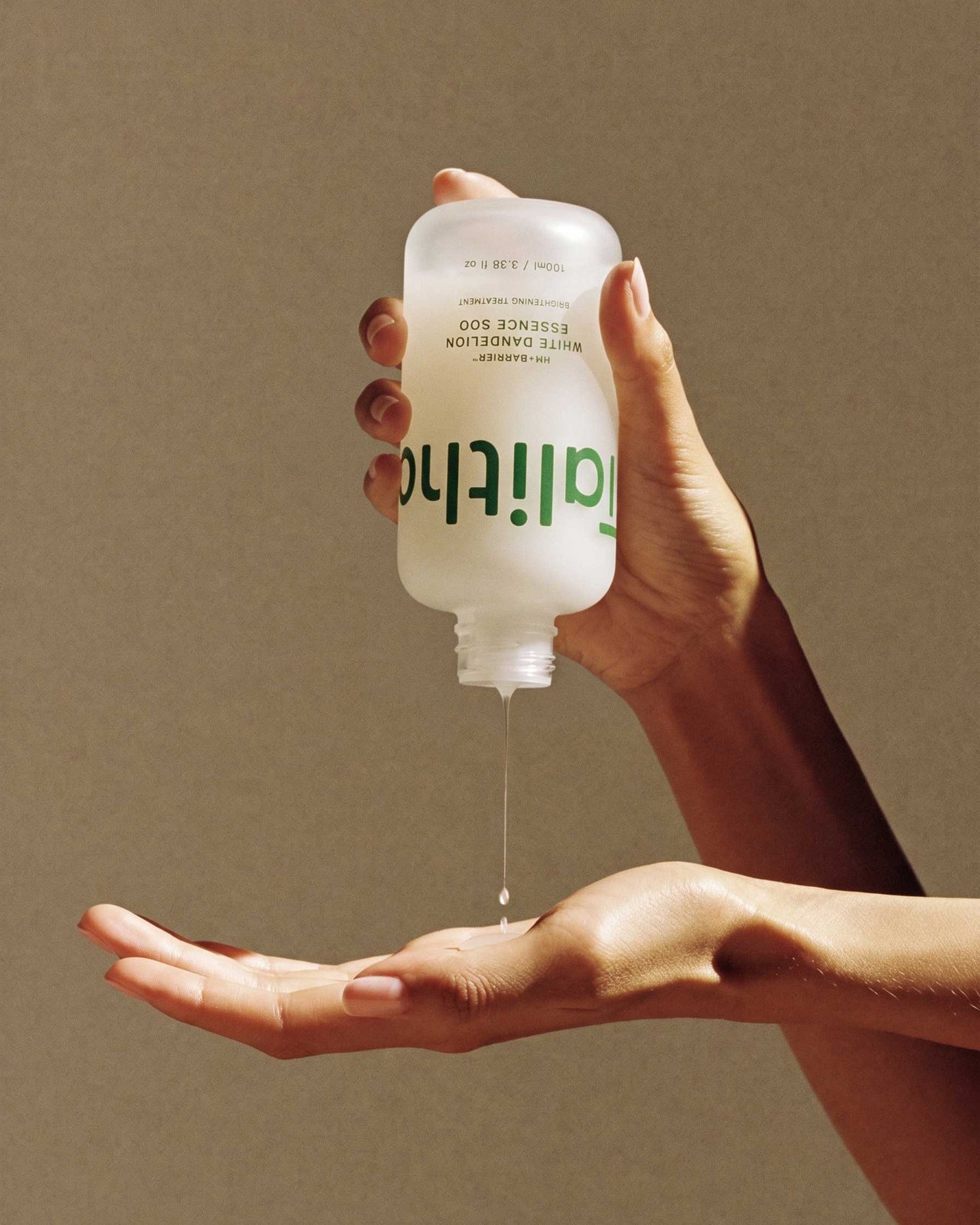 Essence Soo pouring from the bottle into an open palm